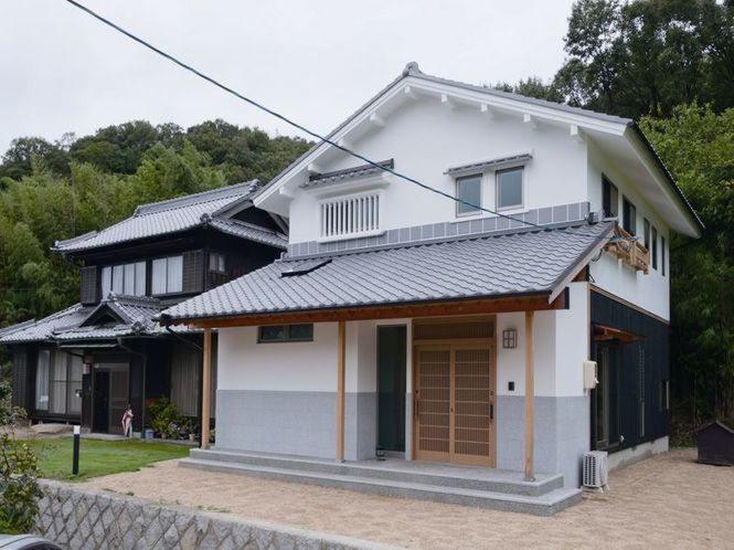 母屋と調和する漆喰と石の蔵風住宅